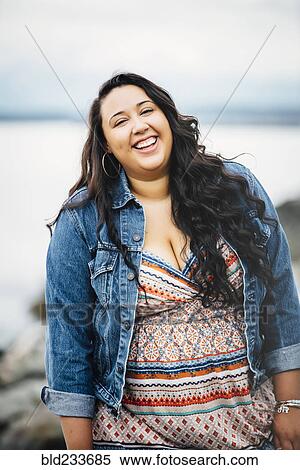 Stock Photography - Smiling Mixed Race woman near ocean. Fotosearch