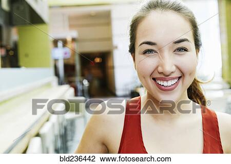 Stock Image - Smiling Mixed Race woman posing in food court. Fotosearch