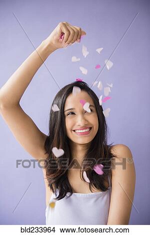 Smiling Mixed Race woman sprinkling heart-shape confetti View Large Photo Image Picture - Smiling Mixed Race woman sprinkling heart-shape confetti. Fotosearch