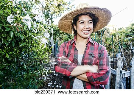 Smiling Mixed Race woman standing in garden View Large Photo Image Stock Image - Smiling Mixed Race woman standing in garden. Fotosearch