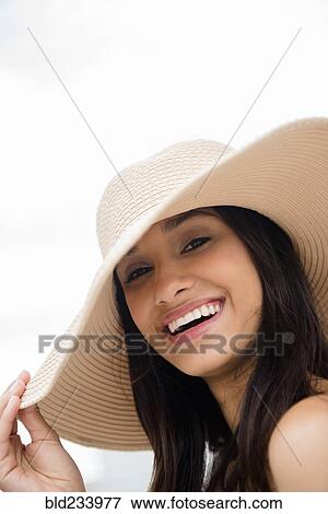 Stock Photo - Smiling Mixed Race woman wearing sun hat. Fotosearch