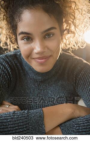 Stock Image - Smiling Mixed Race woman wearing sweater. Fotosearch