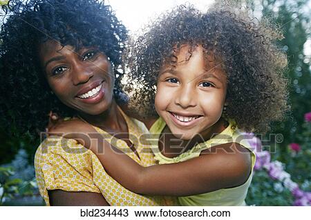 Smiling mother and daughter posing outdoors View Large Photo Image Stock Image - Smiling mother and daughter posing outdoors. Fotosearch