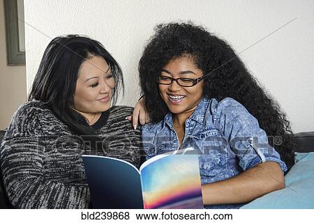 Smiling mother and daughter reading book View Large Photo Image Stock Photo - Smiling mother and daughter reading book. Fotosearch