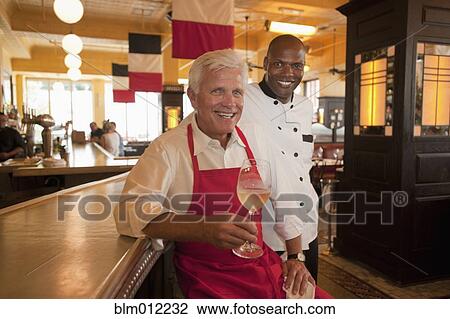 Smiling restaurant waiter and chef View Large Photo Image Stock Image - Smiling restaurant waiter and chef. Fotosearch