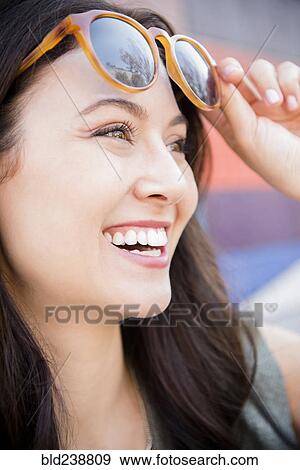 Smiling Thai woman lifting sunglasses View Large Photo Image Stock Photo - Smiling Thai woman lifting sunglasses. Fotosearch