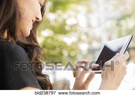 Smiling Thai woman using digital tablet View Large Photo Image Stock Photo - Smiling Thai woman using digital tablet. Fotosearch