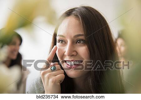 Smiling woman applying moisturizer to face View Large Photo Image Picture - Smiling woman applying moisturizer to face. Fotosearch