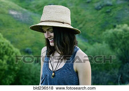 Stock Photo - Smiling woman wearing hat on hill. Fotosearch