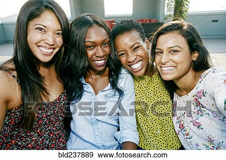 Stock Photo - Smiling women posing on rooftop. Fotosearch