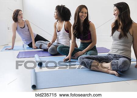 Stock Photography - Smiling women sitting on exercise mats. Fotosearch