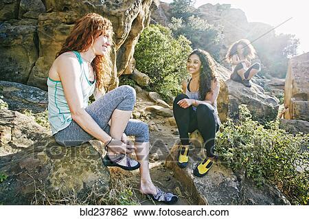 Smiling women sitting on rocks preparing for rock climbing View Large Photo Image Stock Image - Smiling women sitting on rocks preparing for rock climbing. Fotosearch