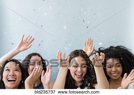 Smiling women throwing confetti View Large Photo Image Stock Photo - Smiling women throwing confetti. Fotosearch