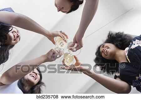 Smiling women toasting with white wine View Large Photo Image Stock Photo - Smiling women toasting with white wine. Fotosearch