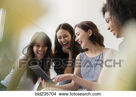 Picture - Smiling women using digital tablet. Fotosearch