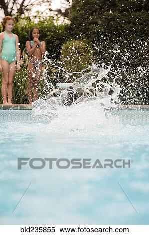 Stock Photography - Splash from girl jumping into swimming pool. Fotosearch