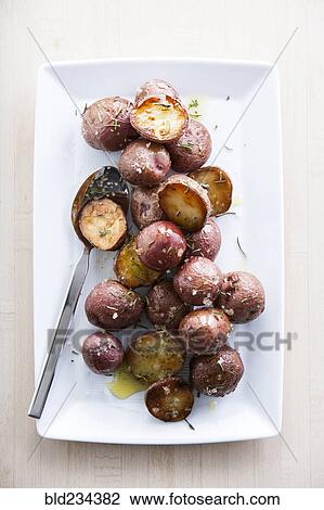 Spoon on plate of roasted potatoes View Large Photo Image Stock Image - Spoon on plate of roasted potatoes. Fotosearch