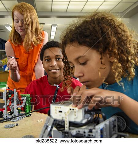 Stock Image - Students assembling plastic blocks in library. Fotosearch
