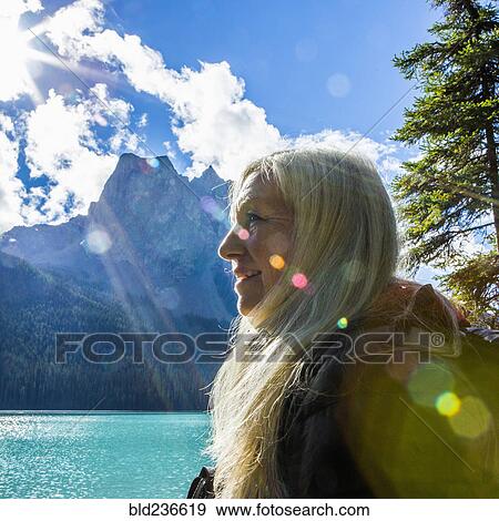 Sunbeams on face of Caucasian woman at mountain lake View Large Photo Image Stock Photo - Sunbeams on face of Caucasian woman at mountain lake. Fotosearch