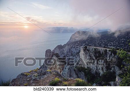 Sunrise from foggy ocean cliff View Large Photo Image Stock Photo - Sunrise from foggy ocean cliff. Fotosearch