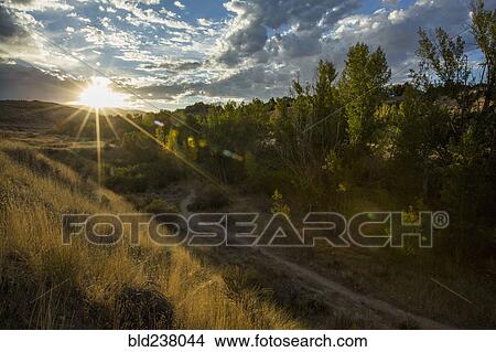 Picture - Sunset over distant mountain path. Fotosearch