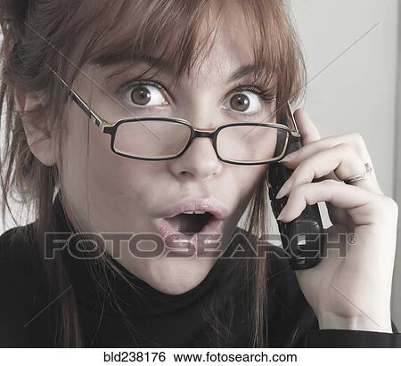 Stock Photograph - Surprised Caucasian businesswoman talking on telephone. Fotosearch