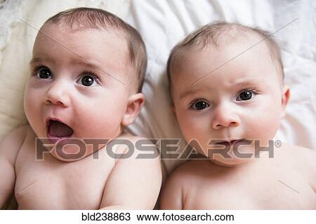 Stock Image - Surprised faces of Caucasian twin baby girls. Fotosearch