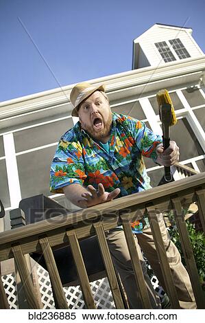 Surprised man barbecuing on patio View Large Photo Image Stock Photography - Surprised man barbecuing on patio. Fotosearch