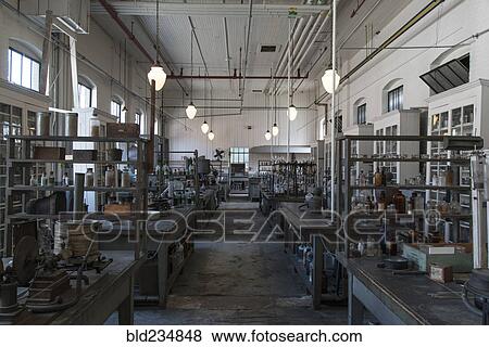Stock Photo - Tables and jars in empty old-fashioned factory. Fotosearch