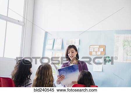 Teacher reading book to girls in classroom View Large Photo Image Stock Photography - Teacher reading book to girls in classroom. Fotosearch