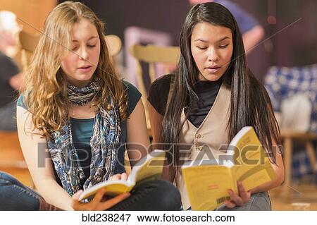 Stock Photo - Teenage girls reading scripts in theater class. Fotosearch