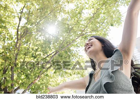 Thai woman celebrating under tree View Large Photo Image Stock Image - Thai woman celebrating under tree. Fotosearch
