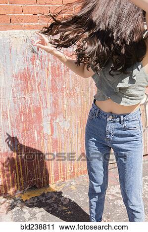 Stock Image - Thai woman dancing on city sidewalk. Fotosearch