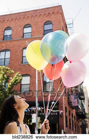 Thai woman holding balloons in city View Large Photo Image Stock Photograph - Thai woman holding balloons in city. Fotosearch