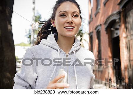 Thai woman jogging in city listening to earbuds View Large Photo Image Stock Image - Thai woman jogging in city listening to earbuds. Fotosearch