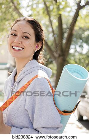 Thai woman posing in city carrying exercise mat View Large Photo Image Picture - Thai woman posing in city carrying exercise mat. Fotosearch