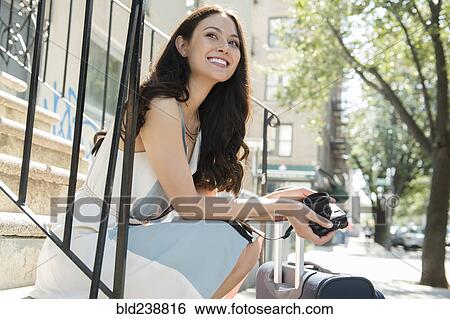 Thai woman sitting on urban staircase with camera and suitcase View Large Photo Image Stock Photograph - Thai woman sitting on urban staircase with camera and suitcase. Fotosearch