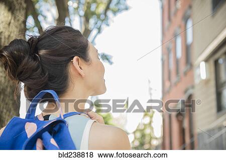 Stock Photo - Thai woman wearing backpack in city. Fotosearch