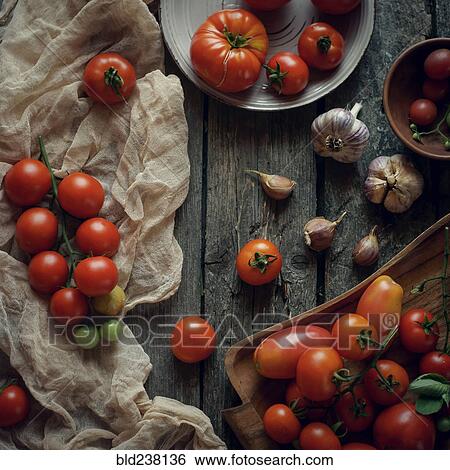 Tomatoes on wooden table View Large Photo Image Stock Photograph - Tomatoes on wooden table. Fotosearch