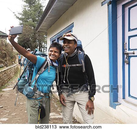 Stock Image - Tourists posing for cell phone selfie. Fotosearch