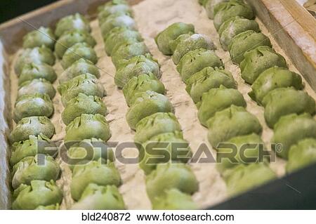Stock Image - Tray of green dumplings. Fotosearch