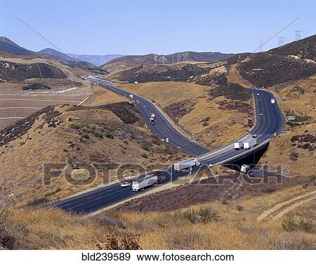 Stock Photo - Trucks and cars driving on freeway overpass. Fotosearch