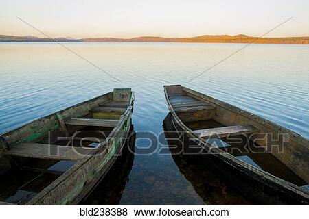 Stock Photo - Two rowboats on lake at sunset. Fotosearch