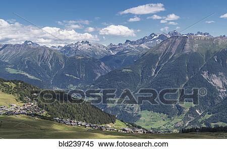 Stock Photography - Village in green valley near mountains. Fotosearch
