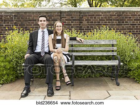 Well-dressed Caucasian couple sitting on bench at park View Large Photo Image Picture - Well-dressed Caucasian couple sitting on bench at park. Fotosearch