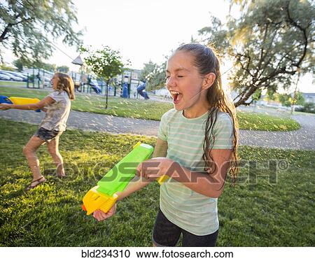 Wet Caucasian girls playing with squirt gun View Large Photo Image Stock Image - Wet Caucasian girls playing with squirt gun. Fotosearch