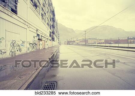 Stock Photography - "Wet street near warehouse with graffiti, Detroit, Michigan, United States". Fotosearch
