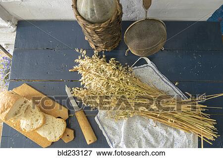 Stock Photo - "Wheat, sliced bread, sieve and bottle on bench". Fotosearch
