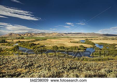 Winding river near mountain range View Large Photo Image Stock Photo - Winding river near mountain range. Fotosearch