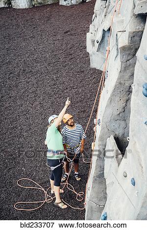 Woman and man looking up at rock climbing wall View Large Photo Image Stock Photo - Woman and man looking up at rock climbing wall. Fotosearch
